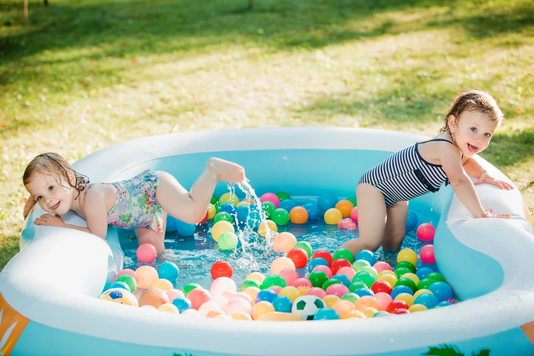 About 3 two_little_baby_girls_playing_with_toys_inflatable_pool_summer_sunny_day_1