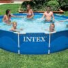 Intex 28210 round metal frame swimming pool set up on a grassy lawn, being filled with water.
